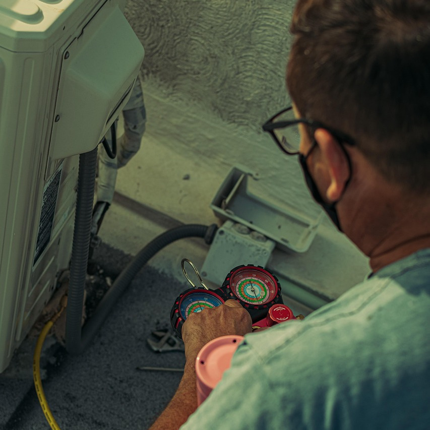 HVAC technician diagnosing AC